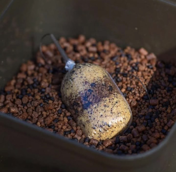 Filled solid PVA bag resting on mixed bait pellets.